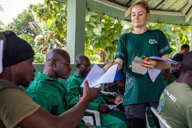 Nature Conserv’Action volunteer, Coline Hervoche, distributes Under the Snakefluence surveys, at a guide training in Côte d’Ivoire. Photo by Michiel van Noppen
