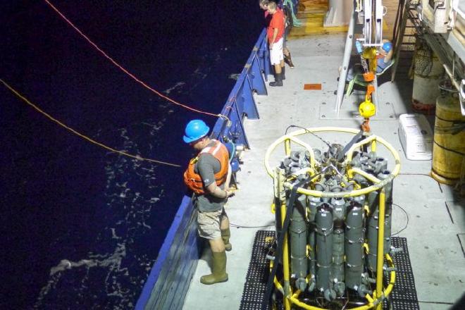 Adam Martiny (centro) participa en la toma de muestras a bordo de un buque oceánico del Global Ocean Ship Hydrographic Investigations Program. Crédito de la imagen: Celine Mouginot / UC Irvine