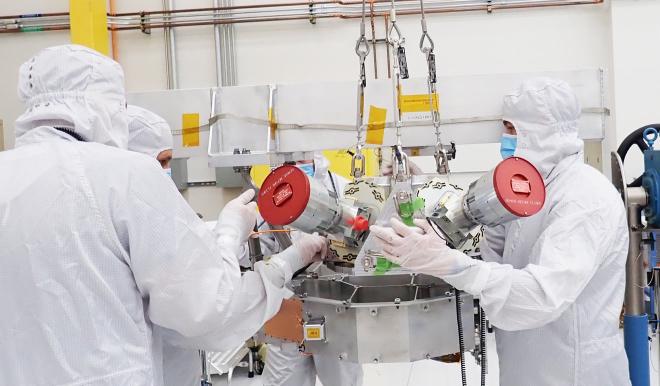 Engineers on NASA’s Europa Clipper mission work with the spacecraft’s star trackers in a clean room at the agency’s Jet Propulsion Laboratory in 2022. Used for orienting the spacecraft, the star trackers are seen here with red covers to protect their lenses. Credit: NASA/JPL-Caltech