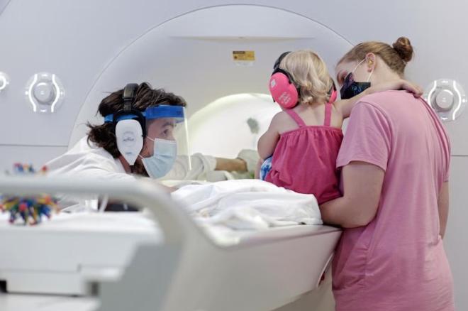 Nick Turk-Browne (left) preparing a child participant and parent for an infant MRI study in the Brain Imaging Center (now BrainWorks) at Yale University circa 2021. Photo credit: 160/90