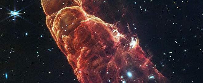 The NASA/ESA/CSA James Webb Space Telescope has captured a beautiful juxtaposition of the nearby protostellar outflow known as Herbig-Haro 49/50 with a perfectly positioned, more distant spiral galaxy. Due to the close proximity of this Herbig-Haro object to the Earth, this new composite infrared image of the outflow from a young star allows researchers to examine details on small spatial scales like never before. With Webb, we can better understand how the jet activity associated with the formation of young stars can affect their surrounding environment.