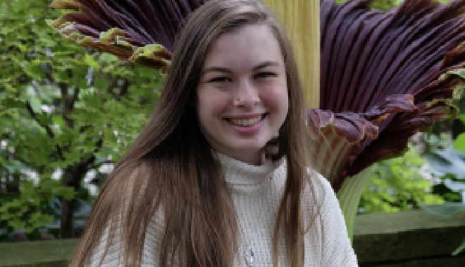 Olivia Murrell sentada delante de una flor cadáver