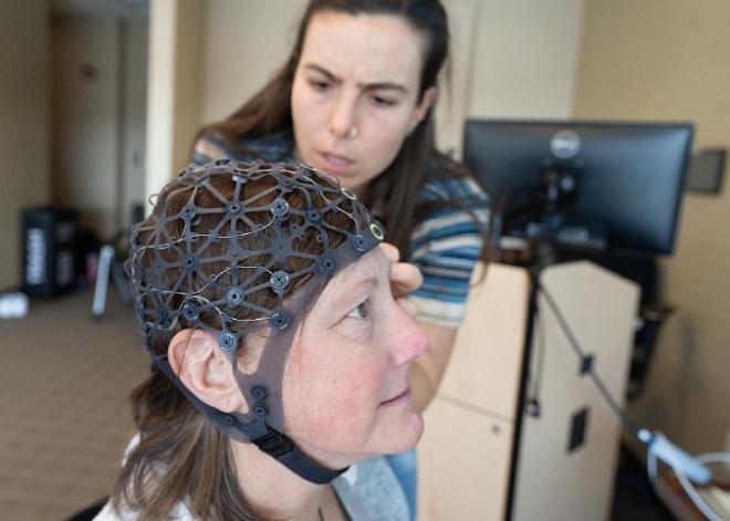 A researcher attach sensors to patient Aimee Kain’s head to monitor her brain activity before and after the eight-week dance therapy program for neuropathy. Credit: The Ohio State University Comprehensive Cancer Center