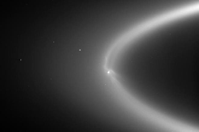 El anillo E de Saturno es un enorme y difuso círculo de partículas con forma de rosquilla alrededor de Saturno, que desconcertó a los científicos durante mucho tiempo. Gracias a la misión Cassini-Huygens, los científicos se dieron cuenta de que el anillo en realidad está creado por partículas que quedaron dejadas por la estela de Encélado, la luna helada de Saturno. Esta imagen, tomada por la sonda Cassini el 15 de septiembre de 2006, a unos 2 millones de kilómetros de Encélado, muestra una columna de vapor que emana de la región polar sur de la luna. Esta columna se forma cuando el agua del océano subterráneo de Encélado brota de las grietas de su superficie helada. Crédito de la imagen: NASA/JPL/Space Science Institute