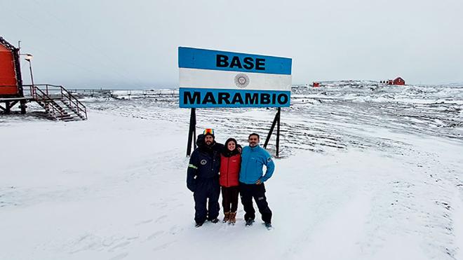 Grupo de trabajo en el cartel de base Marambio en la Campaña Antártica 2022–2023. De izq. a der. Lucas Rubinstein, Noelia Santos y Matías Pereira.