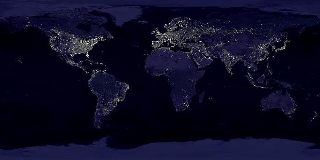 La invención de la luz eléctrica ha permitido observar grandes centros de población humana desde la órbita terrestre baja , demostrando cómo el impacto de la humanidad es visible a escala global. Esta imagen de las luces de las ciudades de la Tierra se creó con datos del Sistema Operacional de Escaneo Lineal (OLS) del Programa de Satélites Meteorológicos de Defensa (DMSP). Diseñado originalmente para observar las nubes a la luz de la luna, el OLS también se utiliza para mapear la ubicación de las luces permanentes en la superficie terrestre. Las zonas más brillantes de la Tierra son las más urbanizadas, pero no necesariamente las más pobladas. (Compárese Europa occidental con China e India). Las ciudades tienden a crecer a lo largo de las costas y las redes de transporte. Incluso sin el mapa subyacente, los contornos de muchos continentes seguirían siendo visibles. El sistema de autopistas interestatales de Estados Unidos aparece como una red que conecta los puntos más brillantes de los centros urbanos. En Rusia, el ferrocarril Transiberiano es una delgada línea que se extiende desde Moscú a través del centro de Asia hasta Vladivostok. El río Nilo, desde la presa de Asuán hasta el mar Mediterráneo, es otro hilo brillante que atraviesa una región que, de otro modo, estaría en penumbra. Incluso más de cien años después de la invención de la luz eléctrica, algunas regiones siguen estando escasamente pobladas y sin iluminación. La Antártida está completamente a oscuras. Las selvas del interior de África y Sudamérica permanecen en su mayoría oscuras, aunque comienzan a aparecer focos de luz. Los desiertos de África, Arabia, Australia, Mongolia y Estados Unidos también están mal iluminados (excepto en las zonas costeras), al igual que los bosques boreales de Canadá y Rusia, y las grandes montañas del Himalaya. Crédito de la imagen: NASA/GFSC. NOAA NGDC