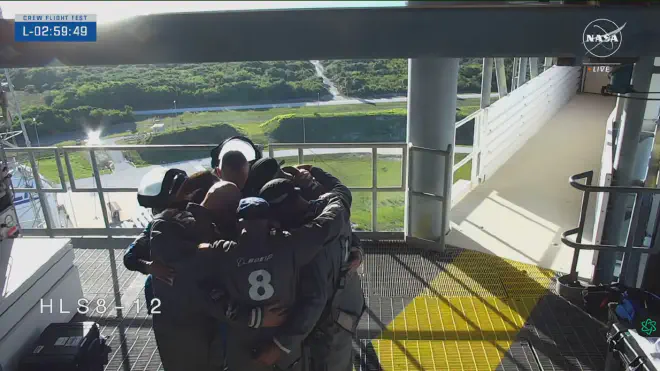 Wilmore and Williams pray next to workers, engineers and technicians, shortly before entering the boarding area of ​​Starliner’s initial flight. Image credit: NASA video screenshot
